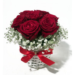 Arrangement of red roses in a small white basket
